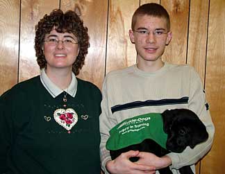 Jonathan holding Covina as a small puppy, while standing next to his mother
