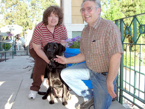 Nabors sitting with his 2 puppy raisers, Barb and Bernie